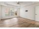 Bedroom featuring tray ceilings, large windows, wood-look flooring and pre-installed TV mount at 401 Wellwood Way, Roswell, GA 30075