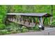Scenic view of a wooden covered bridge surrounded by greenery, foliage, and trees at 401 Wellwood Way, Roswell, GA 30075