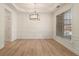 Dining room with wainscoting, stylish light fixture, and a large window at 401 Wellwood Way, Roswell, GA 30075