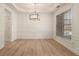 Elegant dining room featuring hardwood floors, wainscoting, and a modern light fixture at 401 Wellwood Way, Roswell, GA 30075