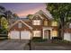 Attractive two-story brick home with well-manicured landscaping, a three-car garage, and inviting entrance at 401 Wellwood Way, Roswell, GA 30075