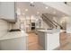 Spacious kitchen featuring a large island, stainless steel appliances and staircase to the upper level at 401 Wellwood Way, Roswell, GA 30075