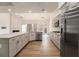 Modern kitchen featuring white cabinetry, stainless steel appliances, stone countertops and wood laminate floors at 401 Wellwood Way, Roswell, GA 30075