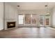 Bright living room with fireplace, hardwood floors, and a large window with natural light at 401 Wellwood Way, Roswell, GA 30075