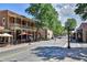 Charming street view with outdoor dining, trees, and buildings with classic architectural details at 401 Wellwood Way, Roswell, GA 30075