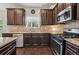 Modern kitchen with dark wood cabinetry, granite counters, stainless steel appliances, and a tile backsplash at 931 Sublime Trl, Canton, GA 30114