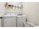 Well-lit laundry room with modern washer and dryer units and wire shelving at 931 Sublime Trl, Canton, GA 30114