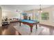 Expansive living room with a pool table, brick fireplace, comfortable seating, and natural light at 931 Sublime Trl, Canton, GA 30114