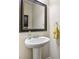 Charming powder room featuring a pedestal sink, framed mirror, and elegant fixtures at 931 Sublime Trl, Canton, GA 30114