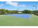Multiple blue tennis courts with lighting, surrounded by trees and community amenities at 931 Sublime Trl, Canton, GA 30114