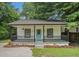 Charming home featuring a welcoming front porch with black railings and a bright blue front door at 1917 Connally Dr, Atlanta, GA 30344