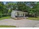 Quaint home with a lovely front porch, black railings, and a well-maintained lawn and gravel driveway at 1917 Connally Dr, Atlanta, GA 30344