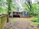 View of the backyard featuring a wooden fence, mature trees, a deck, and lush greenery, perfect for outdoor enjoyment at 195 Burbank Nw Dr, Atlanta, GA 30314