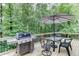 Outdoor deck with dining table, umbrella and grill overlooks lush backyard at 2903 Brookshire Way, Duluth, GA 30096