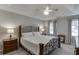 Bedroom featuring a ceiling fan, a tray ceiling, and matching bedside tables and lamps at 2903 Brookshire Way, Duluth, GA 30096