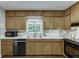 Bright kitchen offers wood cabinets, a double basin sink, and black appliances at 2903 Brookshire Way, Duluth, GA 30096