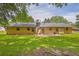 Wide view of home's rear exterior featuring a brick chimney and level backyard at 326 Acaro Ct, Ellenwood, GA 30294