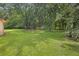 Grassy backyard featuring plenty of shade trees at 326 Acaro Ct, Ellenwood, GA 30294