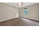 Well-lit bedroom features neutral walls, brown carpet, and a ceiling fan at 326 Acaro Ct, Ellenwood, GA 30294