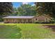 Charming brick home featuring a well-manicured lawn and mature trees providing shade at 326 Acaro Ct, Ellenwood, GA 30294