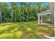 Picturesque backyard view showcasing a spacious lawn, mature trees, and the home's covered patio area at 1114 Low Water Crossing Nw, Acworth, GA 30101