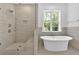 Spa-like bathroom with a soaking tub, glass shower, and neutral tile at 1114 Low Water Crossing Nw, Acworth, GA 30101