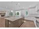 Open-concept kitchen boasts an island, modern stainless steel appliances, white cabinets, and hardwood floors at 1114 Low Water Crossing Nw, Acworth, GA 30101