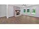 Cozy living room with a white brick fireplace, a ceiling fan and expansive windows offering views of the yard at 1114 Low Water Crossing Nw, Acworth, GA 30101