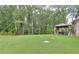 Lush backyard featuring a lawn, mature trees, and a gazebo at 116 Chorley Run, Ellenwood, GA 30294