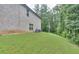 Sloping backyard with brick house featuring a well-manicured lawn at 116 Chorley Run, Ellenwood, GA 30294