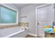 Bathroom featuring soaking tub, tiled accents, and natural light at 116 Chorley Run, Ellenwood, GA 30294