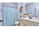 Bathroom featuring a sink, toilet, shower with blue patterned curtain, and decorative shelving at 116 Chorley Run, Ellenwood, GA 30294