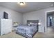 Comfortable bedroom featuring a gray bed, white dresser, and carpet flooring at 116 Chorley Run, Ellenwood, GA 30294
