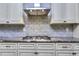 Close up of the cooktop with granite countertops, stylish backsplash, and cabinets at 116 Chorley Run, Ellenwood, GA 30294
