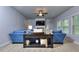Inviting living room featuring plush blue sofas, a cozy fireplace, and ample natural light from large windows at 116 Chorley Run, Ellenwood, GA 30294