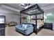 Spacious bedroom with a striking four-poster bed, sitting area, and abundant natural light from the windows at 116 Chorley Run, Ellenwood, GA 30294