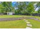 Expansive backyard featuring a stone retaining wall, stepping stone path, a shed, and firepit area at 1442 Pierce Se Ave, Smyrna, GA 30080