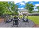 Landscaped backyard featuring a fire pit with chairs, lush lawn, and view of the home's exterior at 1442 Pierce Se Ave, Smyrna, GA 30080