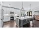 Modern kitchen with white cabinets, stainless steel appliances, an island with seating, and dark hardwood floors at 1442 Pierce Se Ave, Smyrna, GA 30080
