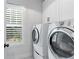 Bright laundry room featuring a stacked washer/dryer and custom shuttered window at 1442 Pierce Se Ave, Smyrna, GA 30080