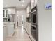 Bright, modern kitchen featuring stainless appliances, double ovens and an adjacent bathroom at 3198 Garden Hill Ln, Douglasville, GA 30135