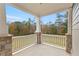 Cozy covered porch features stone columns and a serene view of the landscaped backyard at 3198 Garden Hill Ln, Douglasville, GA 30135
