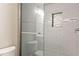 Modern tiled shower with a glass door and built-in niche for toiletries at 3198 Garden Hill Ln, Douglasville, GA 30135