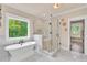Bathroom features a large glass shower, soaking tub, marble floors and natural light at 35 Cornish Creek Ln, Covington, GA 30014