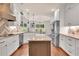 Bright kitchen features white cabinets, stainless steel appliances, granite countertops and a center island at 35 Cornish Creek Ln, Covington, GA 30014