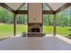 Covered patio features stone fireplace, exposed beams, and a view of the lush backyard at 35 Cornish Creek Ln, Covington, GA 30014