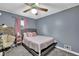 Stylish bedroom with a comfortable bed, soft pink accents, and a ceiling fan for a serene atmosphere at 102 Bascomb Drive Dr, Woodstock, GA 30189