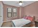Charming bedroom with a cozy bed, soft lighting, and two windows offering natural light and a peaceful ambiance at 102 Bascomb Drive Dr, Woodstock, GA 30189