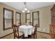 Cozy dining room with natural light from three windows, complemented by a charming chandelier and classic furniture at 102 Bascomb Drive Dr, Woodstock, GA 30189
