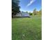 Lovely home exterior showcasing a spacious lawn, driveway, and mature trees against a blue sky at 102 Bascomb Drive Dr, Woodstock, GA 30189